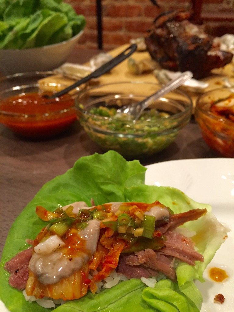     Prepare your lettuce wrap, add some rice, pork, an oyster, kimchi, both sauces.